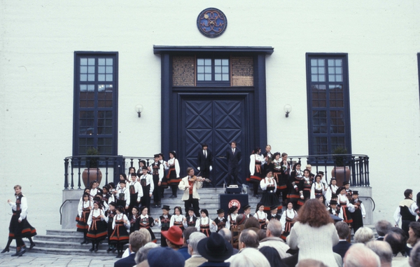 Fra åpningen av museets 100-årsjubileum i 1994.Norsk Folkemuseums dansegruppe, i setesdalsdrakter, med spillemann på trappen utenfor  Hovedbygg, bygning nummer 316 på Norsk Folkemuseum.