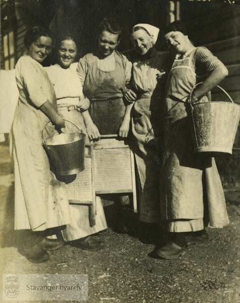 Tjenestejenter foran klesvask
